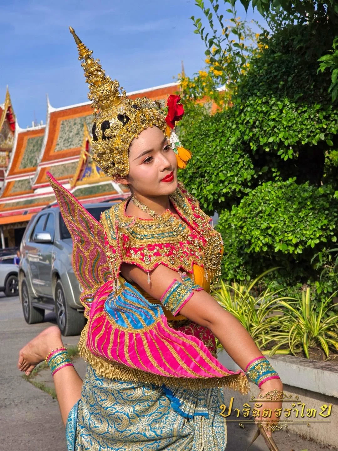 ผู้แสดงชุดปีกสีชมพูและฟ้าในท่ารำ