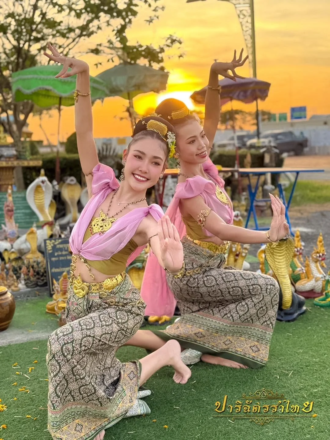 นางรำสองคนห่มสไบสีชมพูในแสงยามเย็น