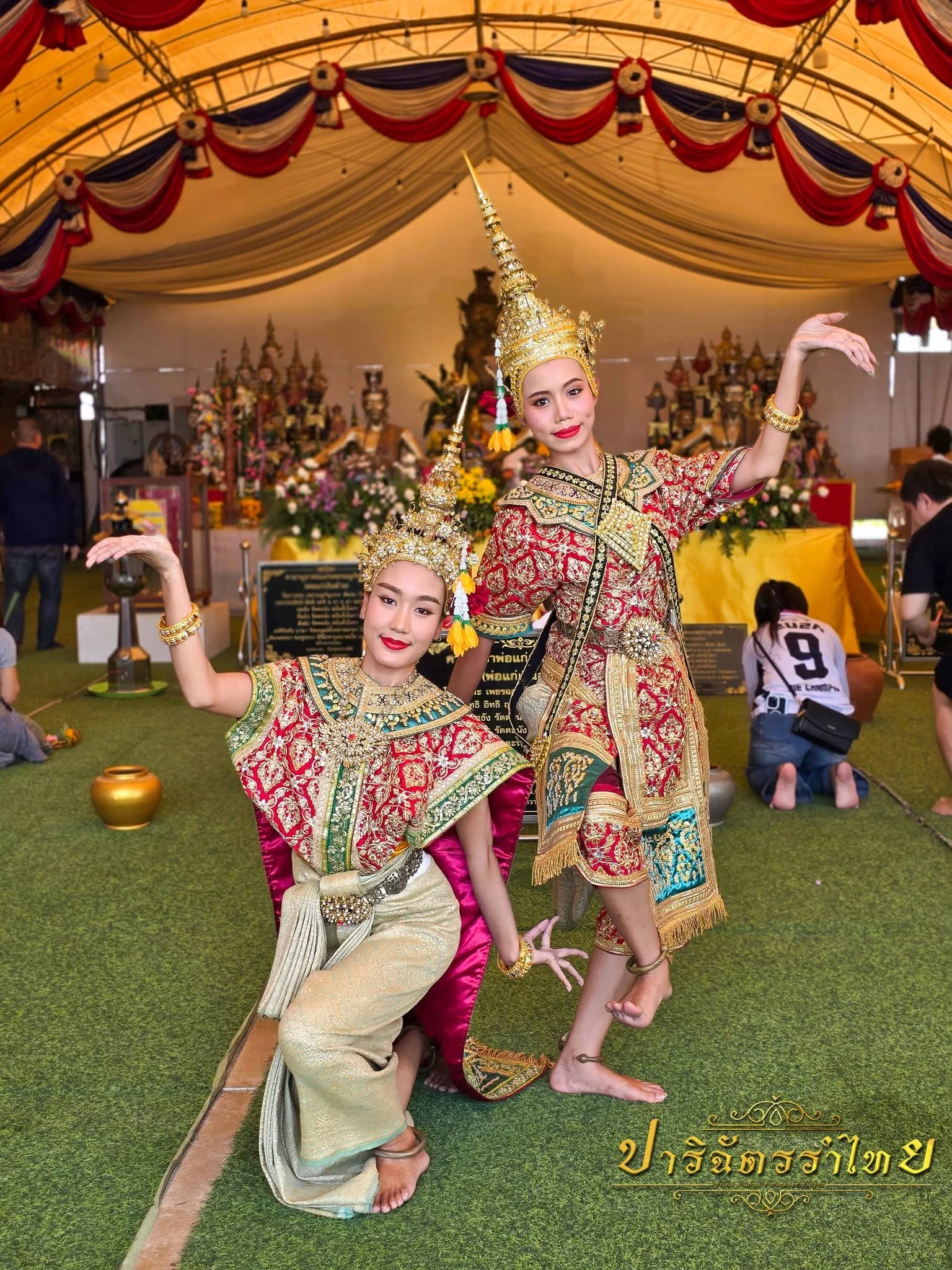 ผู้แสดงสองคนในชุดยืนเครื่องสีแดงทองภายในงานพิธี