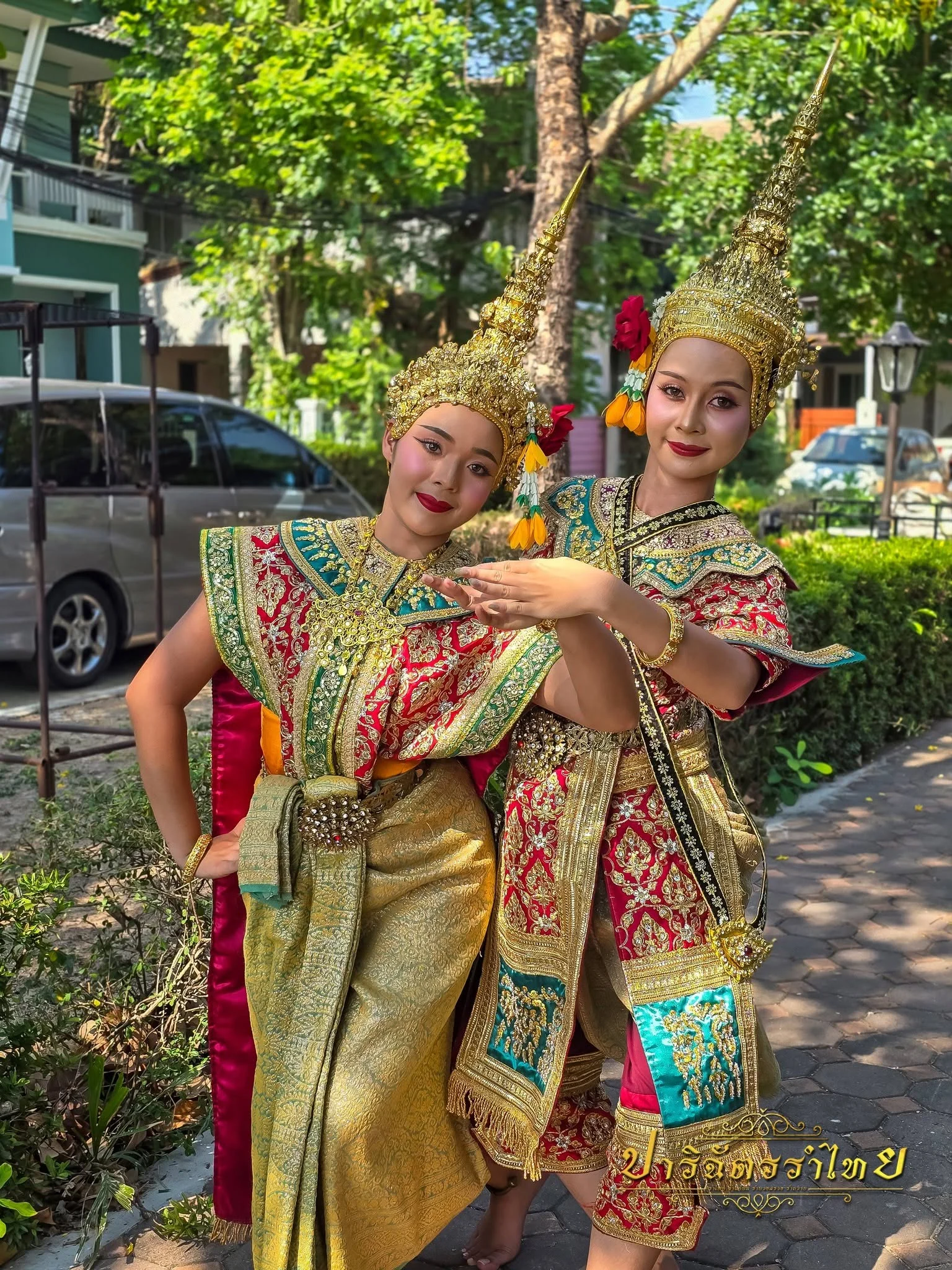 ผู้แสดงสองคนในชุดยืนเครื่องสีแดงทองกลางแจ้ง